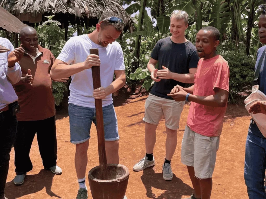 Men gather around a large pot on a fire and have lively conversations. Materuni Waterfalls day trip.